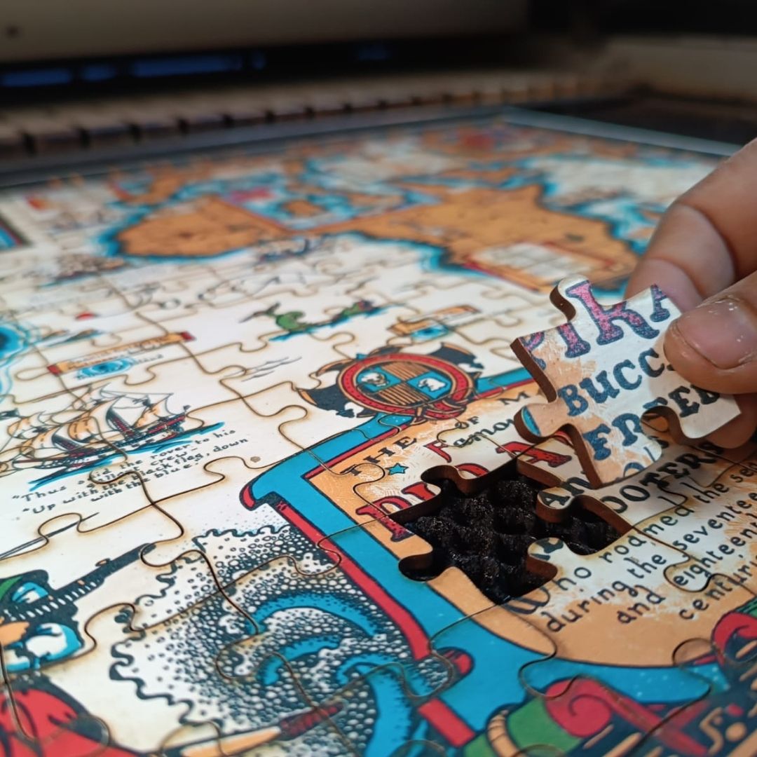 wooden jigsaw held, handcrafted artisanal puzzle of a vintage pirate map
