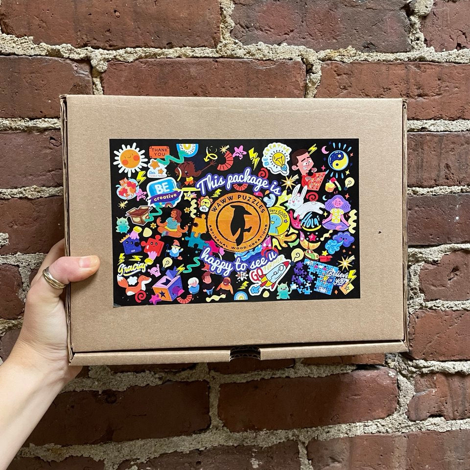 cardboard box containing a wooden jigsaw puzzle by waww artisanal