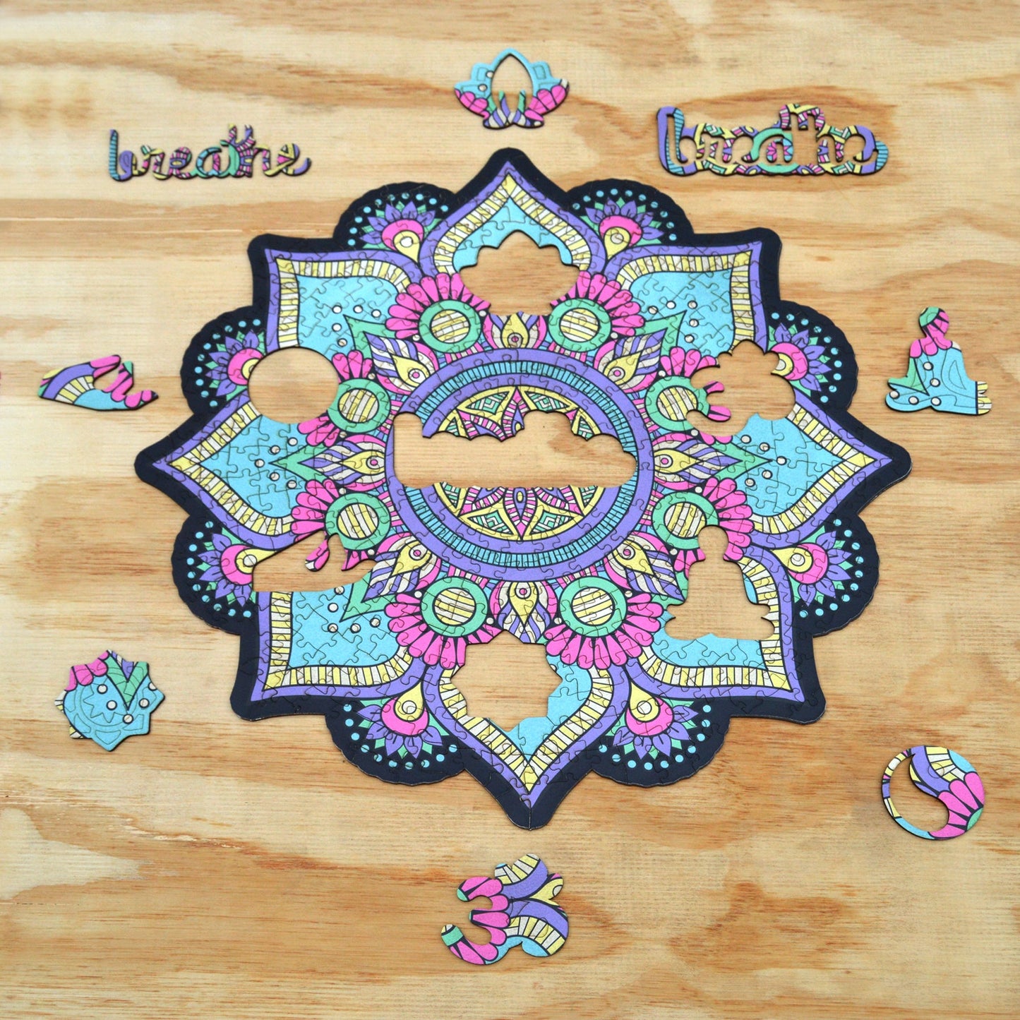 colorful mandala wooden jigsaw puzzle with a geometrical design and flower-like center. It has the mantra or word Breath in the center of the puzzle.