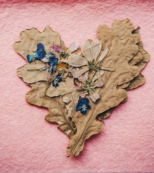 a heart shaped leaf with flowers on it