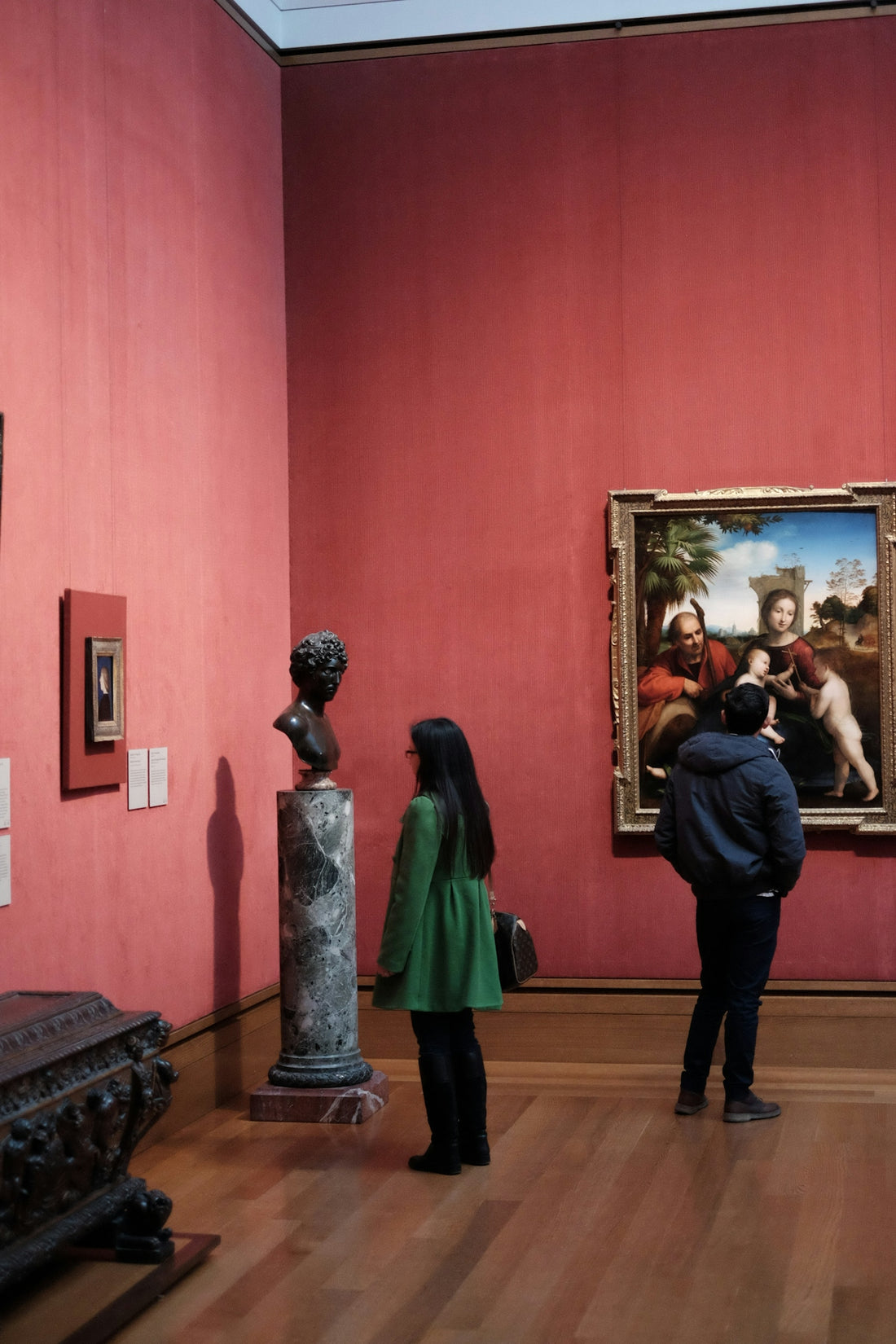 People examine art pieces in a museum.