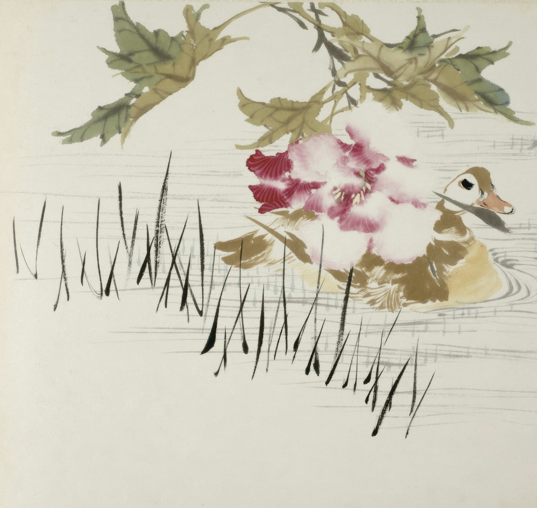 A duck swims near a blooming flower and reeds.