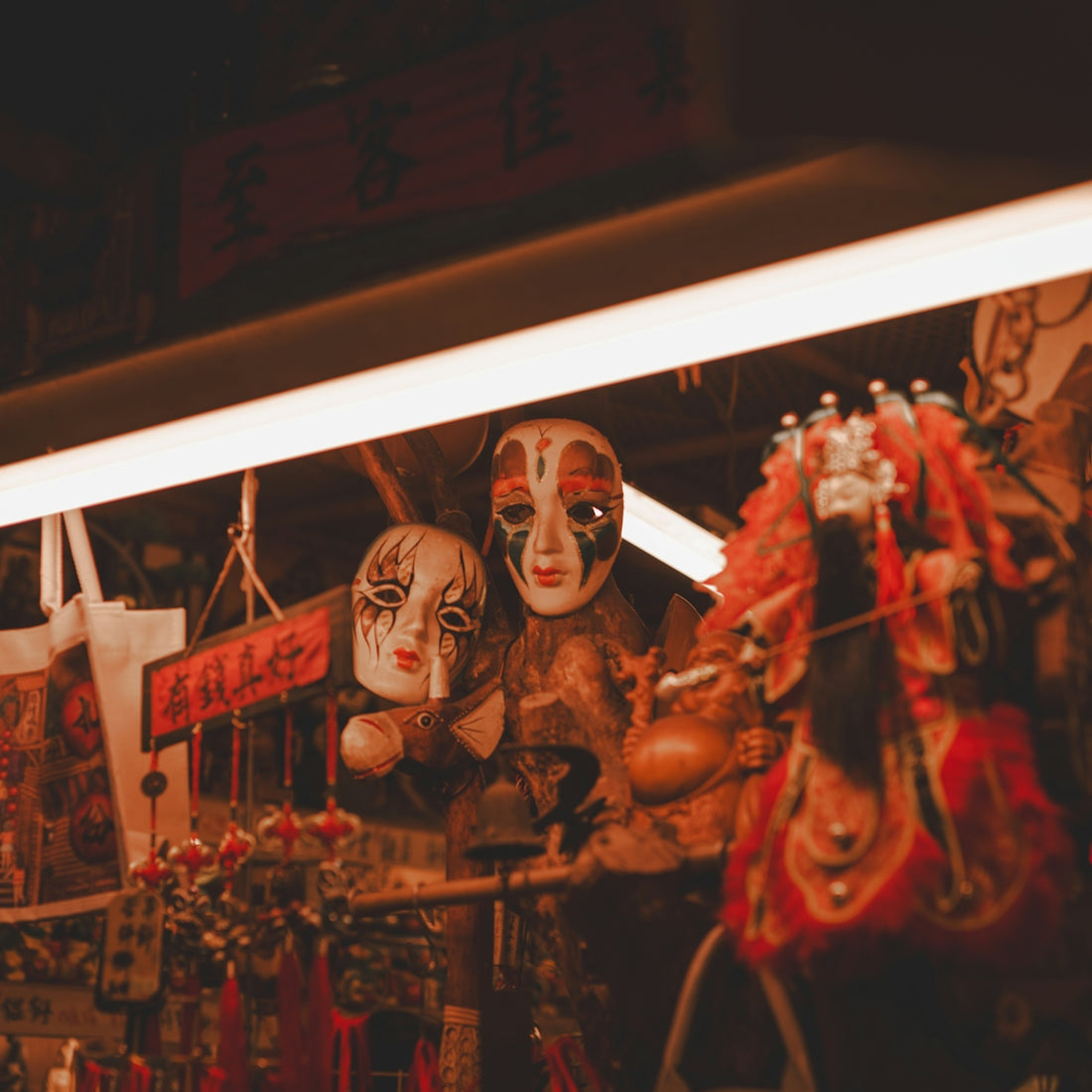Two theatrical masks hang near a horse puppet