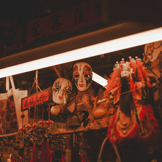 Two theatrical masks hang near a horse puppet
