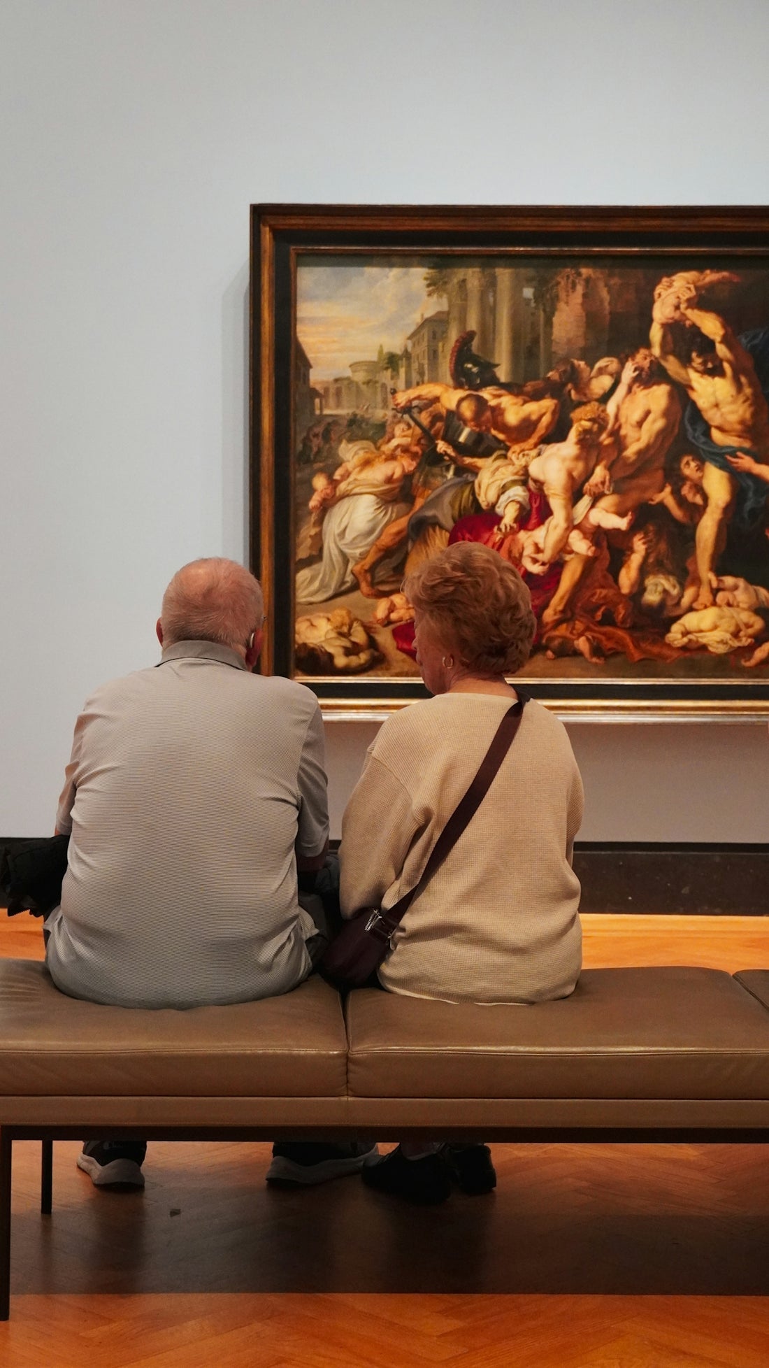 Elderly couple viewing a large painting in an art gallery.
