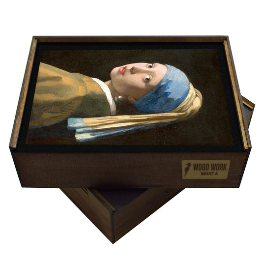A wooden jigsaw puzzle featuring Johannes Vermeer’s Girl with a Pearl Earring, showcasing a young woman in a blue and gold turban with a luminous pearl earring, set against a dark background. A stunning, elegant art puzzle for collectors.