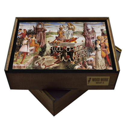 A Renaissance wooden jigsaw puzzle featuring Francesco del Cossa’s Triumph of Venus, depicting Venus on a chariot drawn by swans, surrounded by mythological figures, including the Three Graces, satyrs, and cupids, in a lively spring celebration.