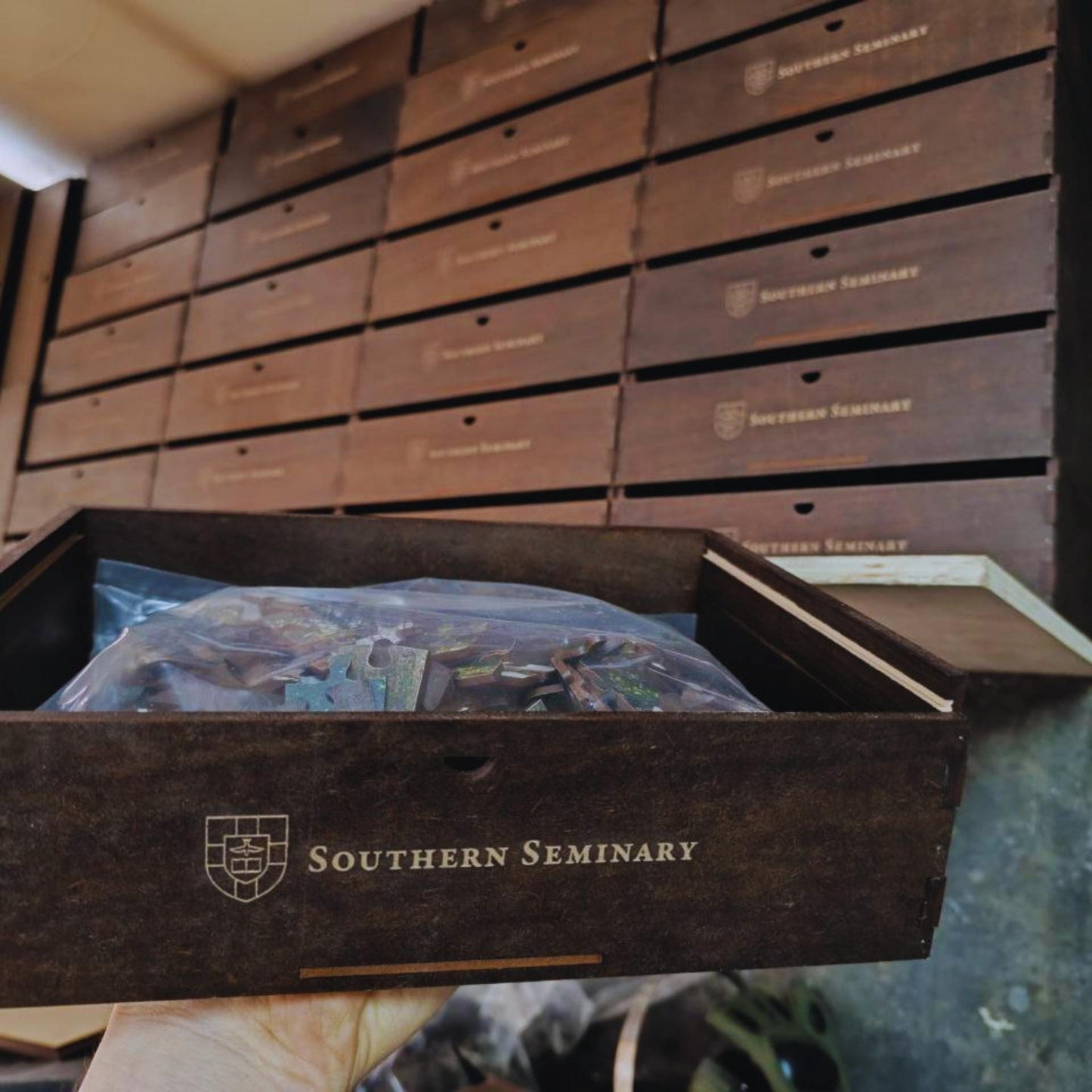 Wooden puzzle box with 'Southern Seminary' branding on a table.