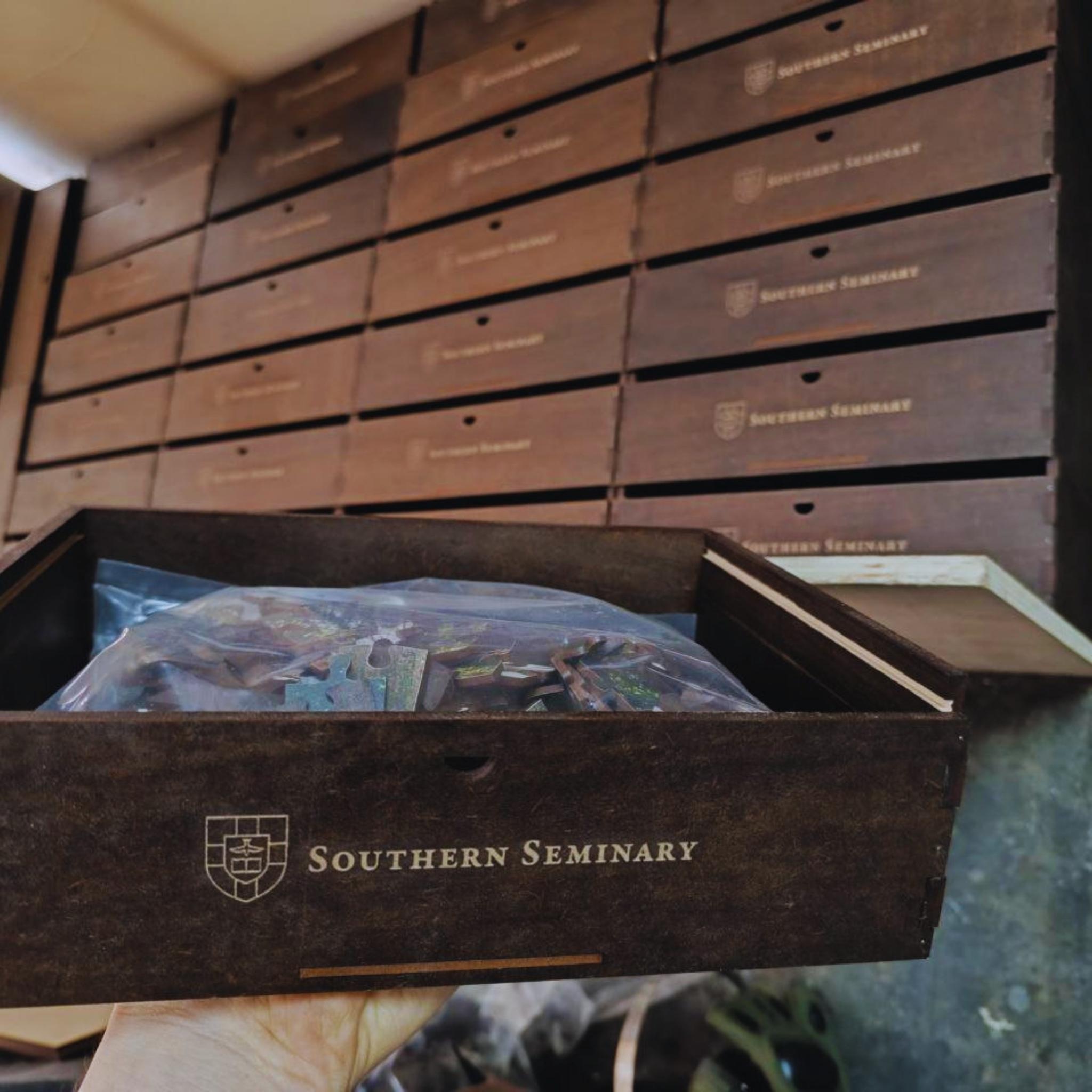 Wooden puzzle box with 'Southern Seminary' branding on a table.