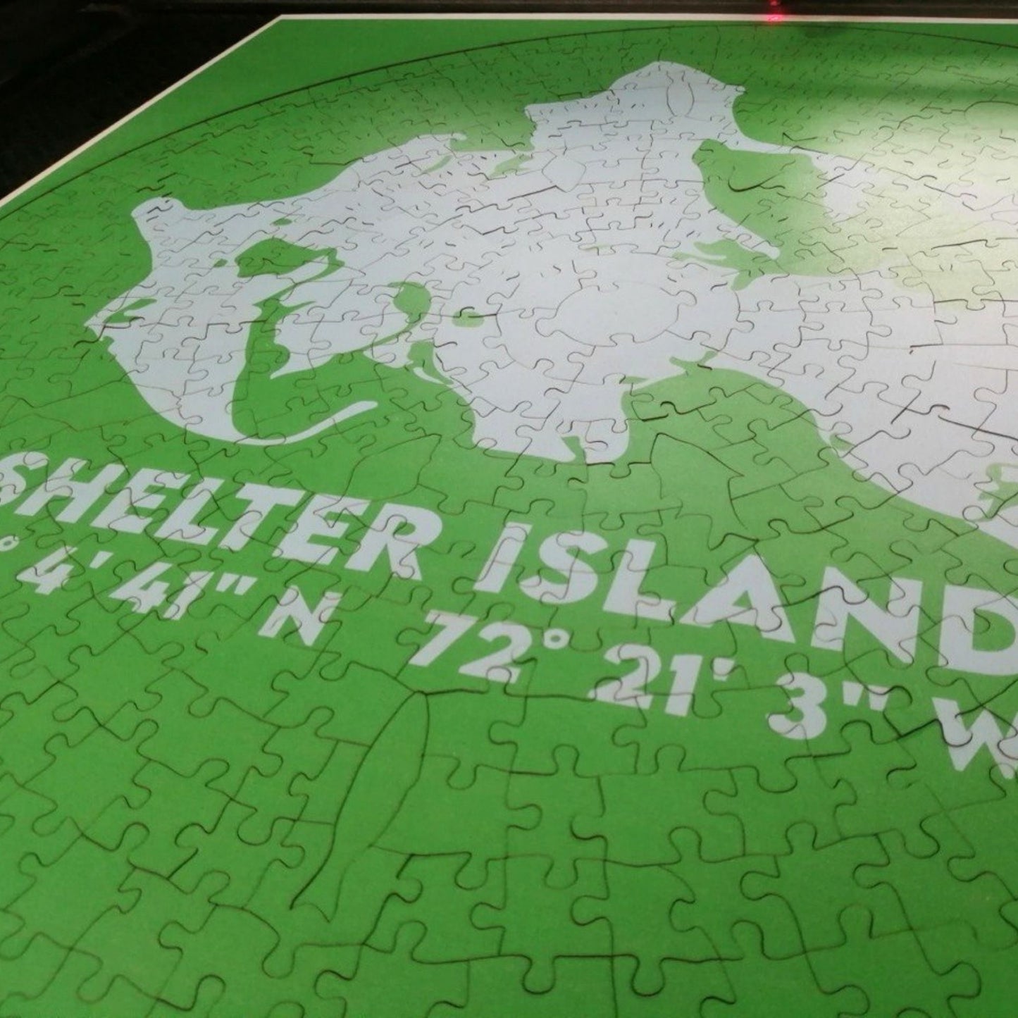 Jigsaw puzzle of Shelter Island with latitude and longitude coordinates on a green background