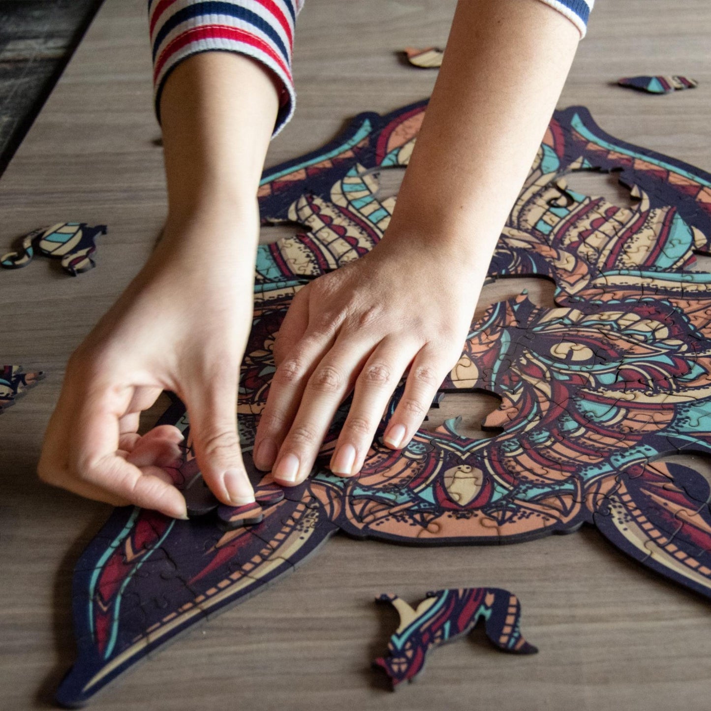 hands holding jigsaw pieces of a Colorful Wolf Wooden Jigsaw Puzzle: Stylized wolf with a vibrant, patterned body. Intricate wooden puzzle
