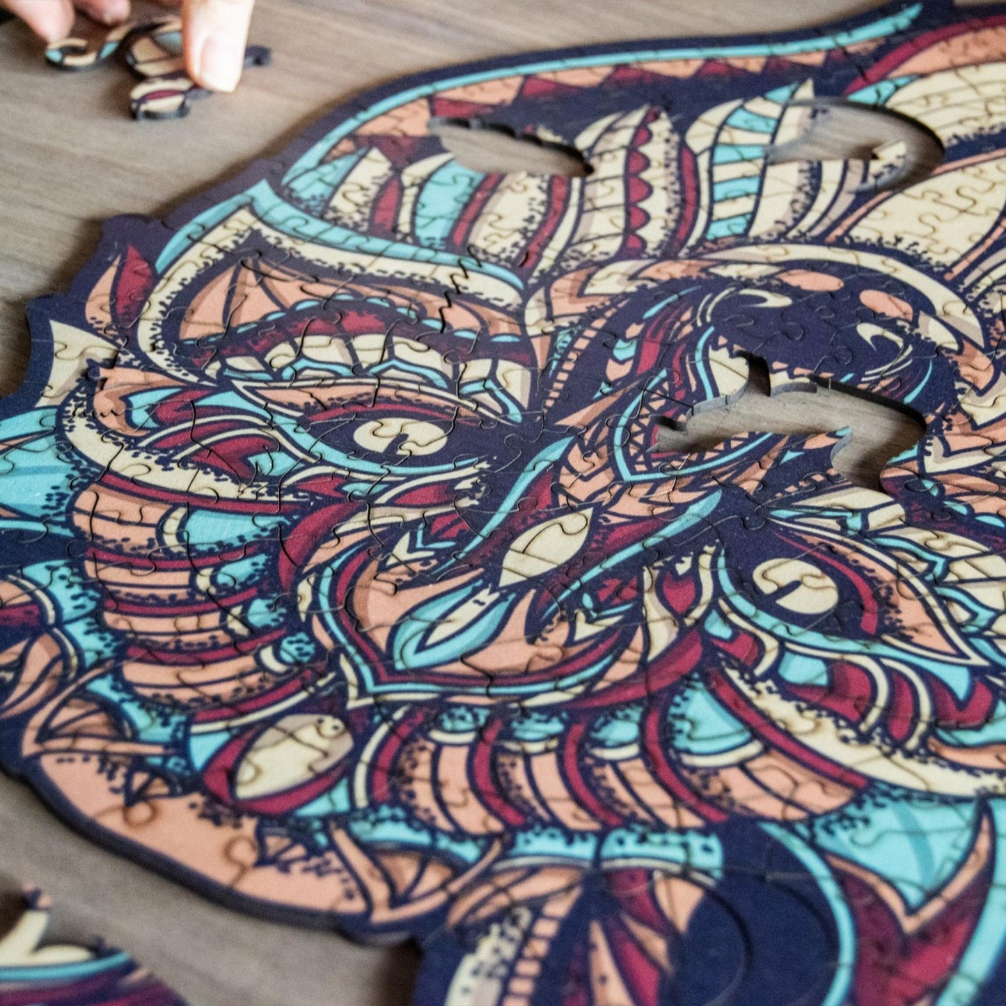 hands holding jigsaw pieces of a Colorful Wolf Wooden Jigsaw Puzzle: Stylized wolf with a vibrant, patterned body. Intricate wooden puzzle
