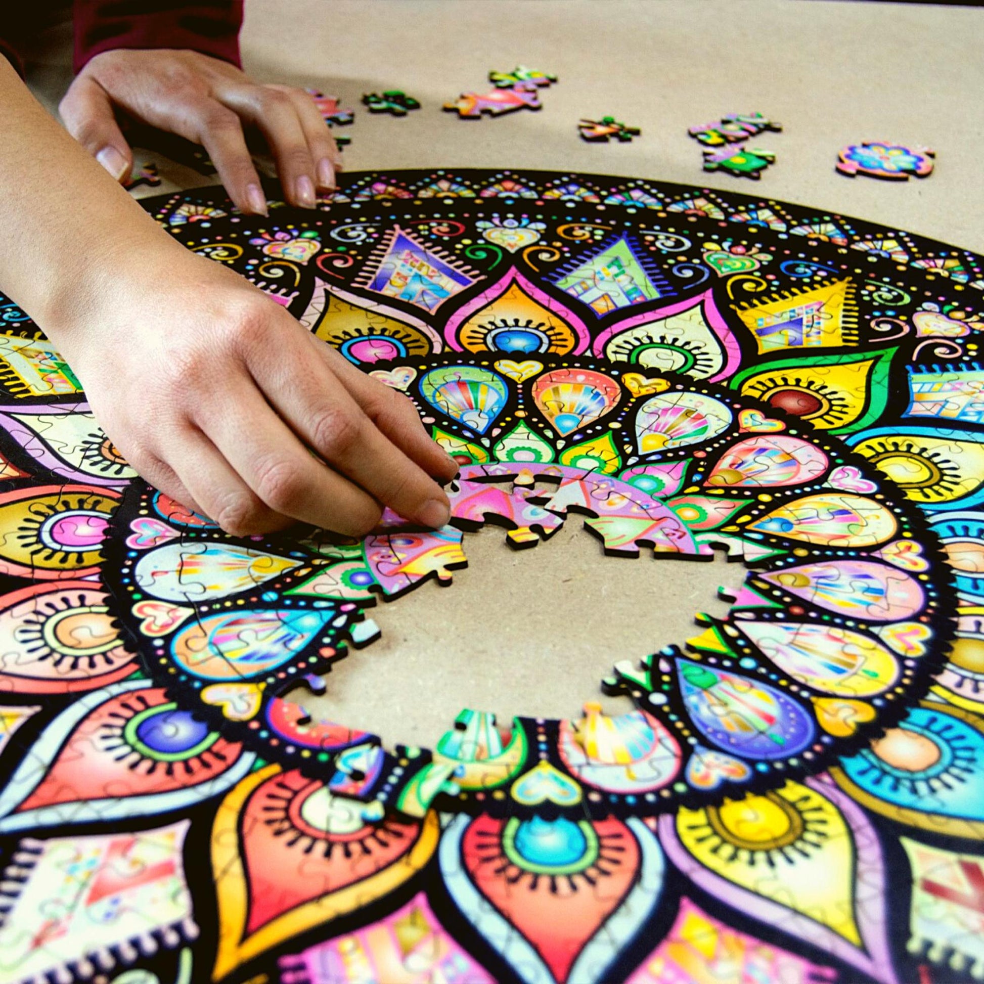 hands holding a colorful jigsaw of a mandala puzzle. Wooden jigsaw, intricate art design.