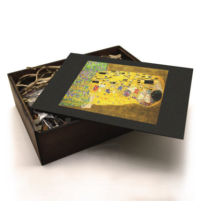 A high-quality wooden jigsaw puzzle of Gustav Klimt’s "The Kiss," featuring a golden embrace of two lovers wrapped in intricate Art Nouveau patterns and floral embellishments. Comes in a handmade wooden keepsake box.